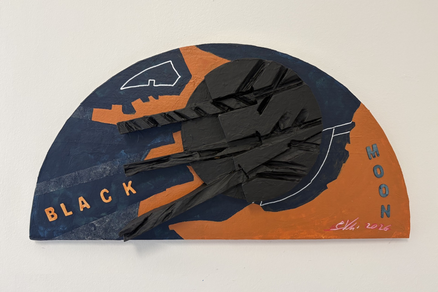 Fotografia di uno scultoquadro semicircolare intitolato "Black Moon", firmato e datato 2026. L'opera è dipinta in blu notte e arancione bruciato, con una forma nera tridimensionale sfaccettata e sporgente al centro, che ricorda un disco eclissato da cui si irradiano elementi appuntiti simili a raggi o crepe scolpite. Sullo sfondo blu, in alto a sinistra, è tracciato in bianco il contorno stilizzato di un profilo di montagne o di uno skyline. Le scritte "BLACK" e "MOON" sono composte da lettere tridimensionali color arancione, applicate rispettivamente in basso a sinistra (su una fascia diagonale blu-grigia) e in verticale sul lato destro dell'opera.